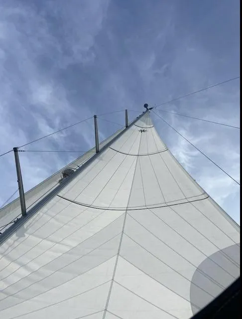 Slide: The Image of Sail of a 2016 Jeanneau Yachts 58 against a clear blue sky. - 4