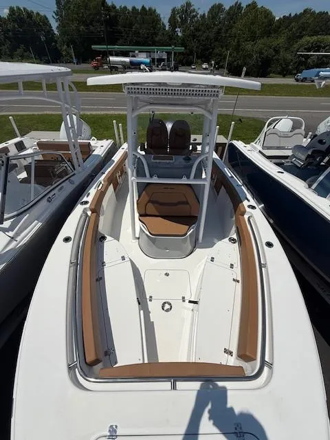 The Image of 2025 Sea Pro 222 Center Console boat with tan seating and white hull, docked outdoors. - 1