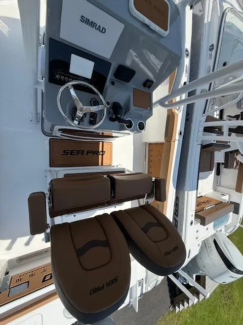 Slide: The Image of 2025 Sea Pro 222 Center Console boat interior with Simrad electronics and brown seating. - 5
