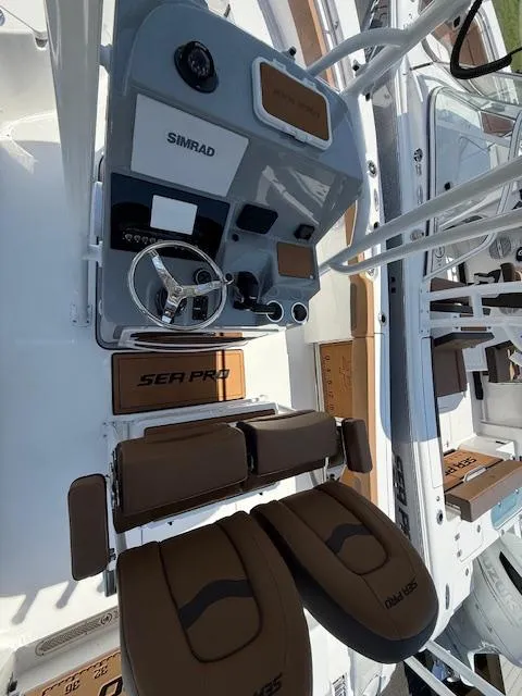 Slide: The Image of 2025 Sea Pro 222 Center Console boat interior with Simrad electronics and brown seating. - 6