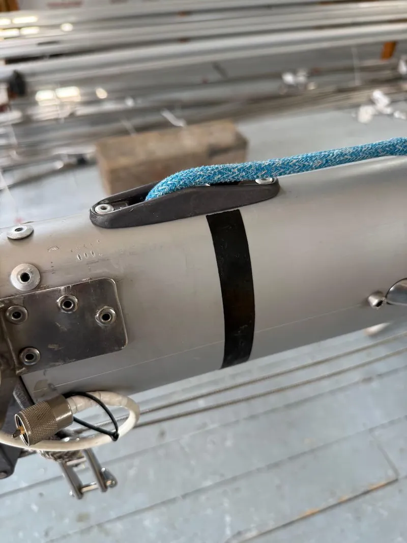 Slide: The Image of Close-up of a 2006 Mas Mini Transat 6.50 sailboat mast with blue rope and fittings. - 11