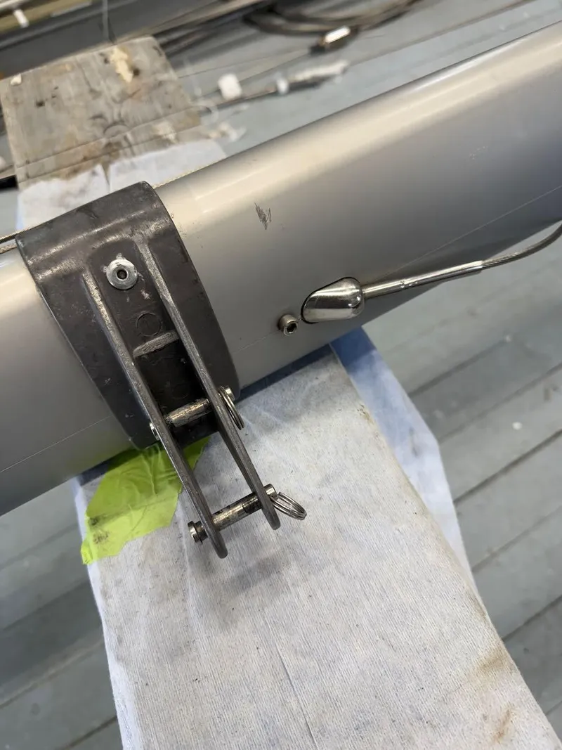 Slide: The Image of Close-up of a 2006 Mas Mini Transat 6.50 sailboat mast fitting on a wooden surface. - 13