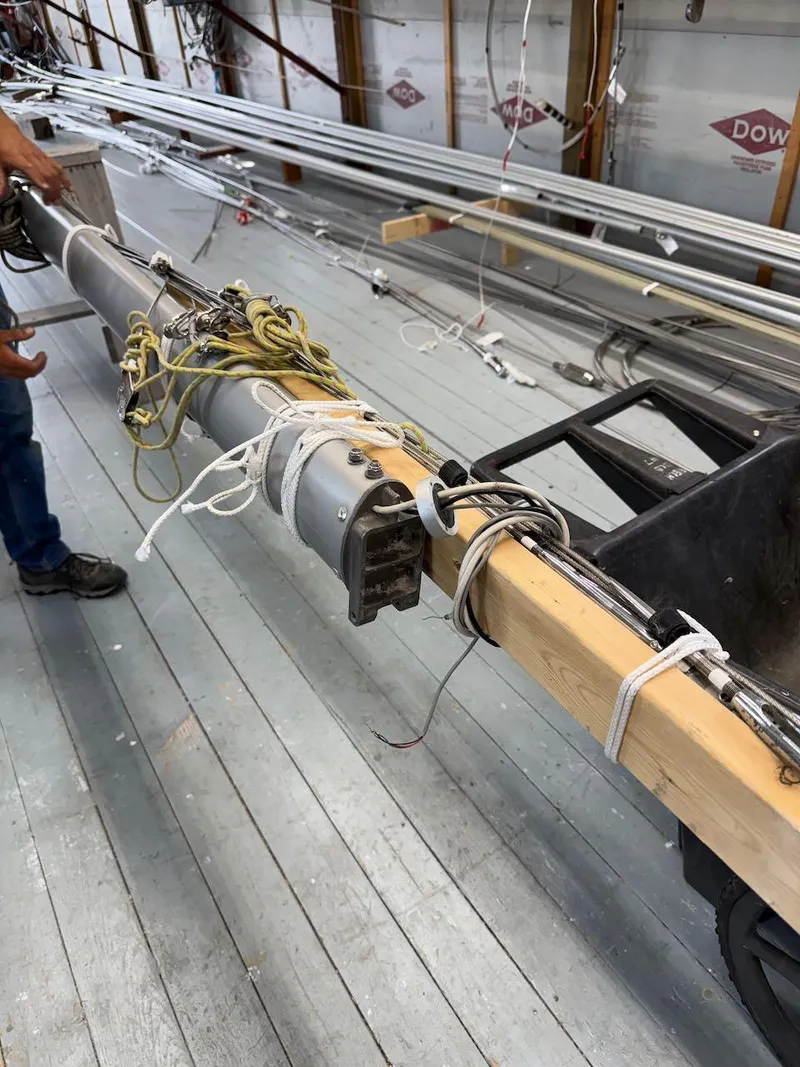 Slide: The Image of Mast of 2006 Mas Mini Transat 6.50 sailboat in workshop, with ropes and fittings. - 17