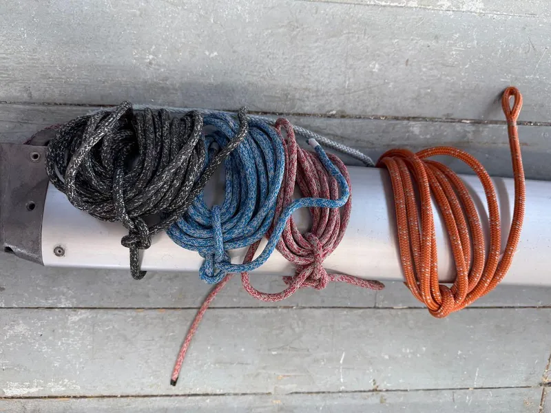 Slide: The Image of Coiled ropes on a 2006 Mas Mini Transat 6.50 sailboat deck. - 19