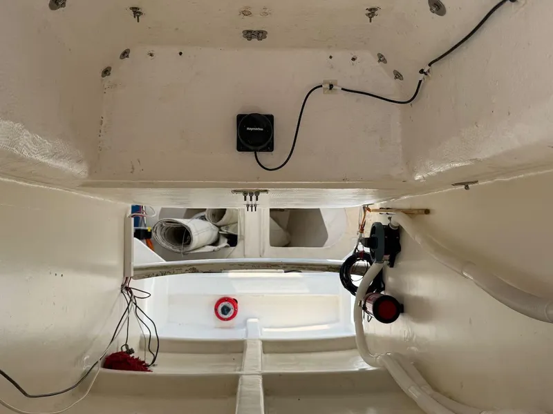 Slide: The Image of Interior view of a 2006 Mas Mini Transat 6.50 sailboat, showing wiring and equipment. - 27