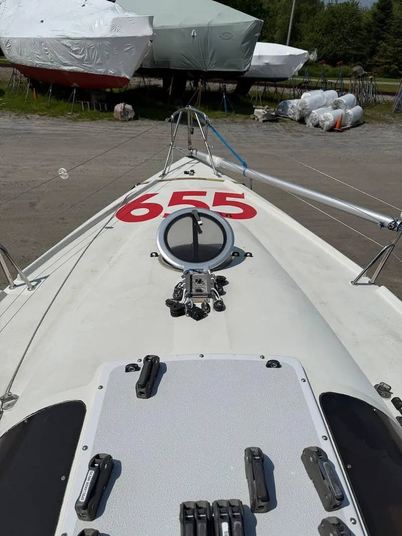 Slide: The Image of 2006 Mas Mini Transat 6.50 sailboat with number 655, docked and covered. - 32