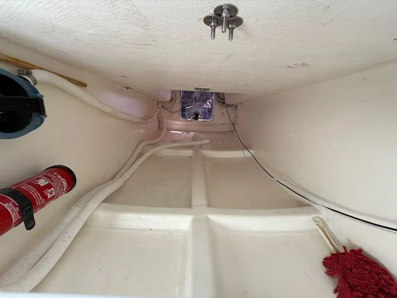 Slide: The Image of Interior of 2006 Mas Mini Transat 6.50 sailboat, featuring fire extinguisher and cleaning supplies. - 46