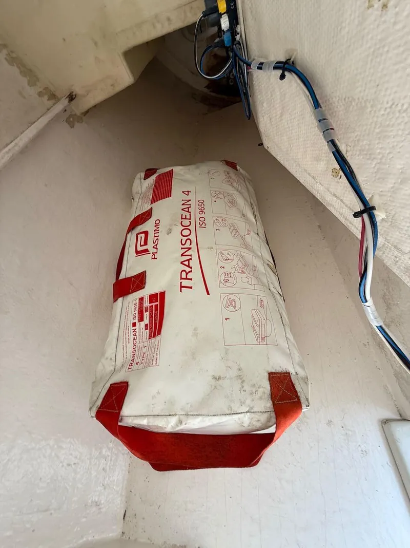 Slide: The Image of Life raft in a 2006 Mas Mini Transat 6.50 sailboat storage compartment. - 47