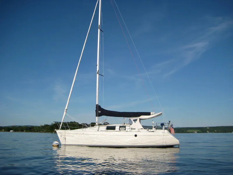 The Image of 1989 Beneteau 32s5 sailboat on calm water under clear blue sky. - 0