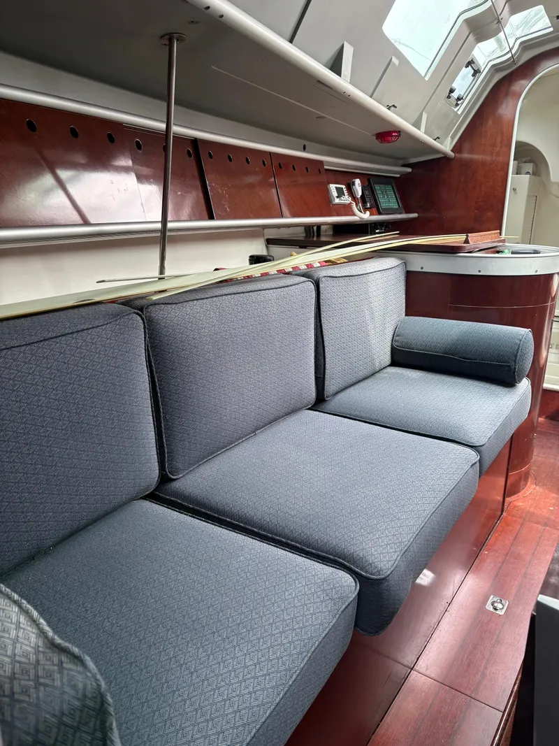 Slide: The Image of Interior of 1989 Beneteau 32s5 yacht with blue cushioned seating and wooden accents. - 31