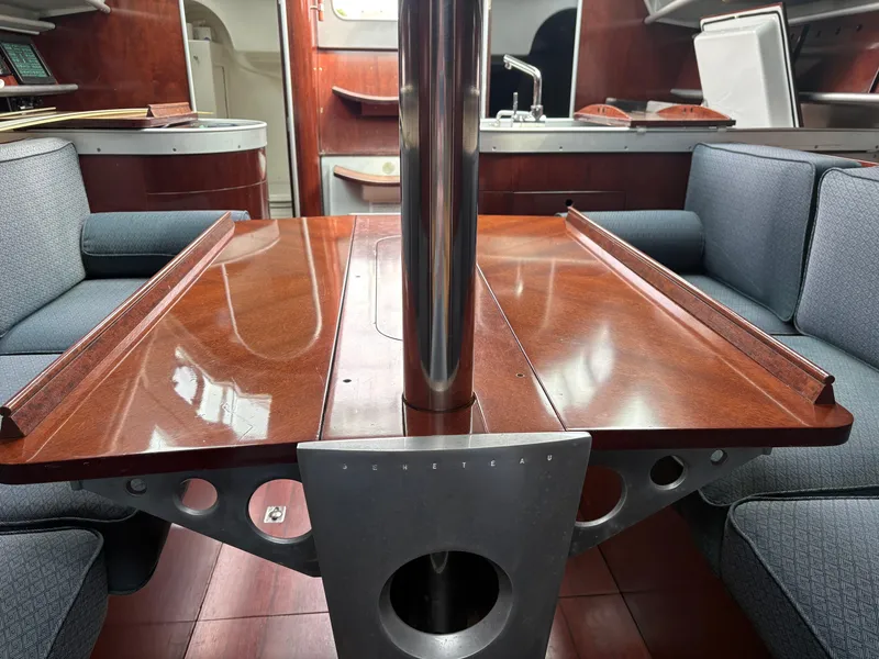 Slide: The Image of Interior of a 1989 Beneteau 32s5 sailboat with wooden table and blue seating. - 33