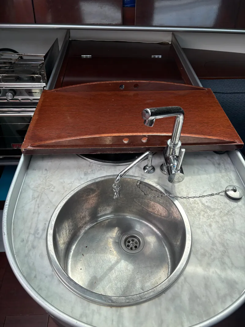 Slide: The Image of 1989 Beneteau 32s5 yacht kitchen sink with wooden cover and stainless steel faucet. - 42