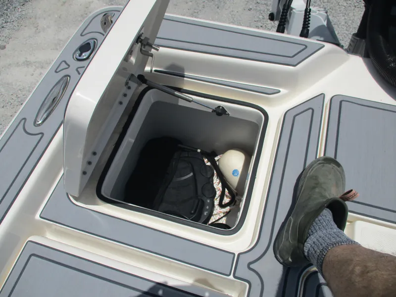 Slide: The Image of Open storage compartment on 2023 Skeeter SX 240 boat with gear inside. - 11