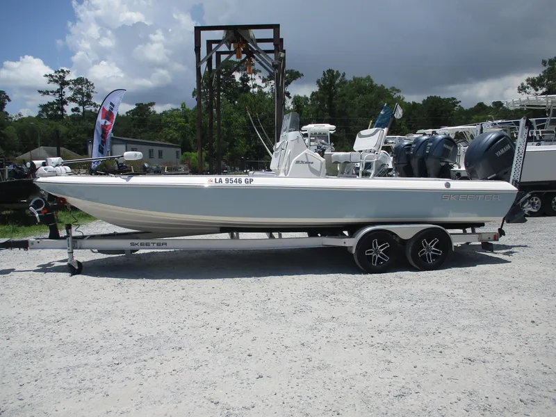 Slide: The Image of 2023 Skeeter SX 240 boat on trailer, displayed outdoors under cloudy sky. - 4