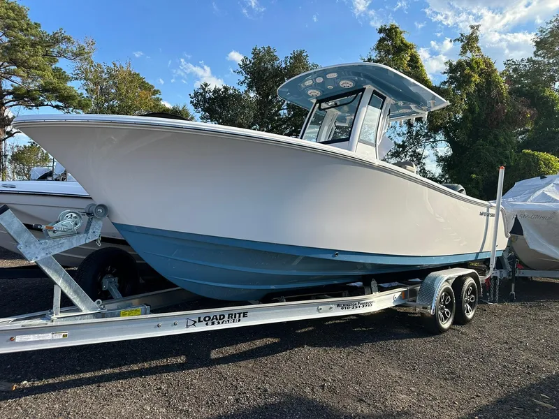 The Image of 2025 Sportsman Open 232 Center Console boat on trailer, parked outdoors. - 0