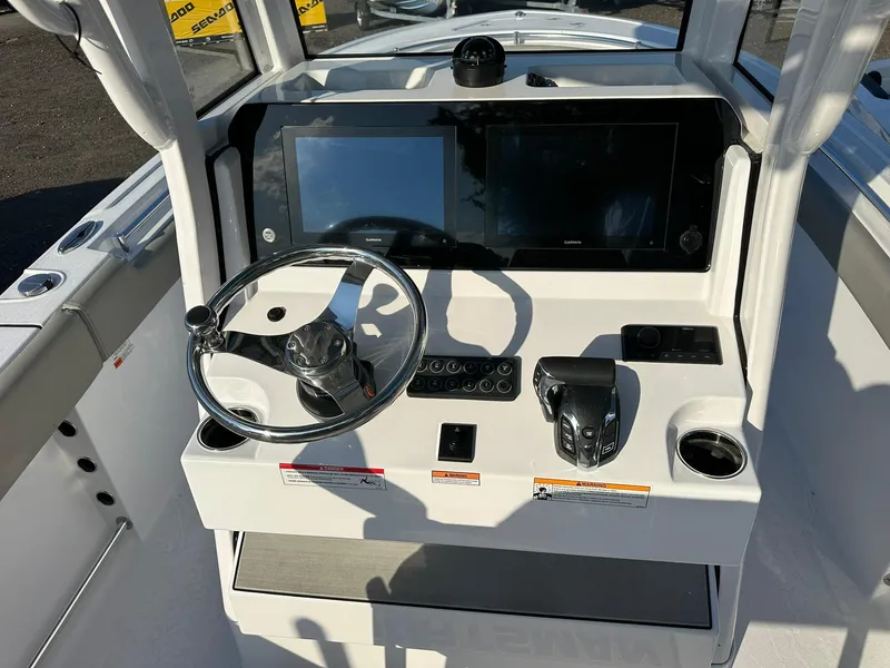 Slide: The Image of 2025 Sportsman Open 232 Center Console boat dashboard with steering wheel and digital displays. - 12