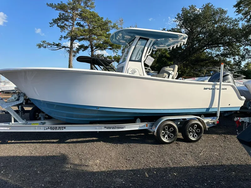 Slide: The Image of 2025 Sportsman Open 232 Center Console boat on trailer, parked outdoors. - 2