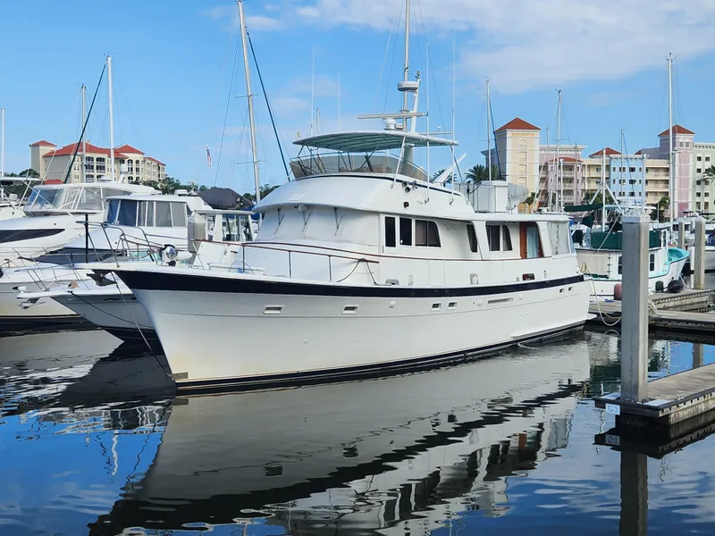 The Image of 1979 Hatteras 58 Long Range Cruiser docked in a marina, surrounded by other boats. - 0