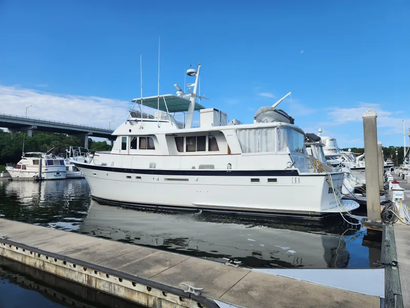 Slide: The Image of 1979 Hatteras 58 Long Range Cruiser docked at marina under clear blue sky. - 1