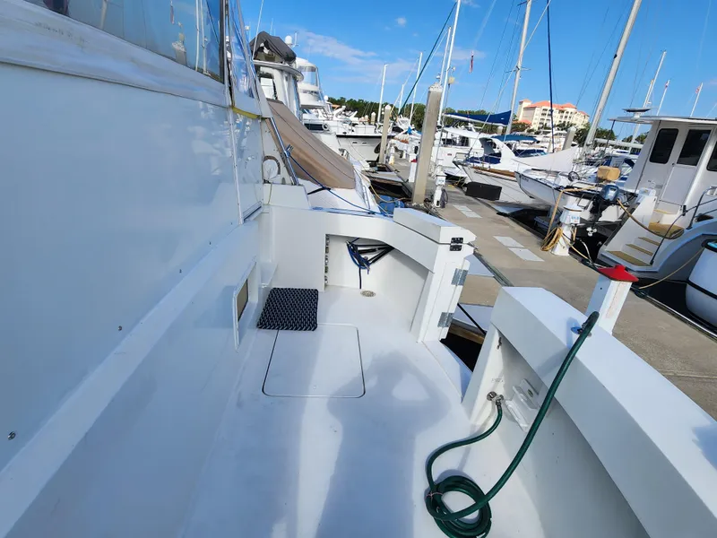 Slide: The Image of 1979 Hatteras 58 Long Range Cruiser docked at marina, showing deck and surrounding boats. - 10