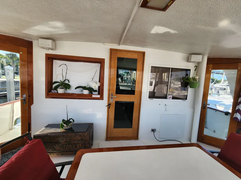 Slide: The Image of Interior of 1979 Hatteras 58 Long Range Cruiser with wooden doors and potted plants. - 13