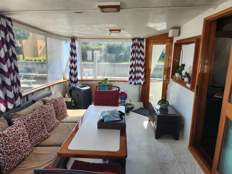 Slide: The Image of Interior of 1979 Hatteras 58 Long Range Cruiser with cozy seating and decorative curtains. - 15