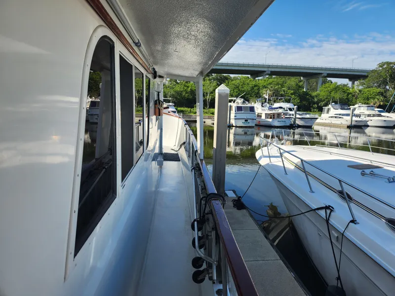 Slide: The Image of 1979 Hatteras 58 Long Range Cruiser docked at a marina under a clear blue sky. - 18