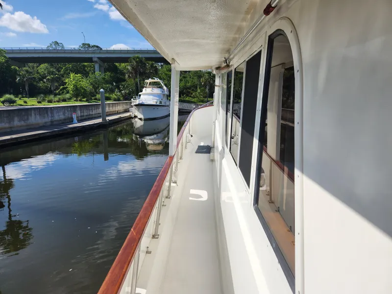 Slide: The Image of 1979 Hatteras 58 Long Range Cruiser docked in a serene canal setting. - 19