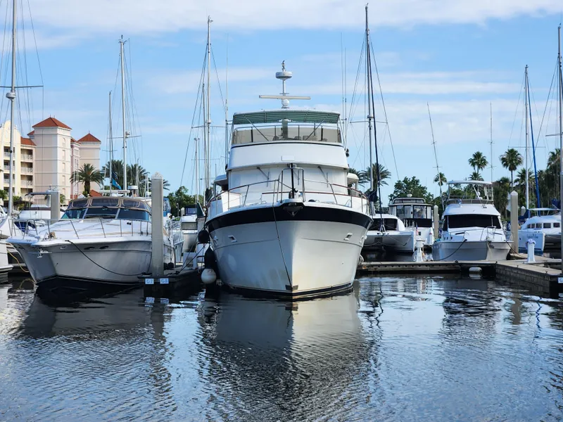 Slide: The Image of 1979 Hatteras 58 Long Range Cruiser docked at marina with other boats. - 2