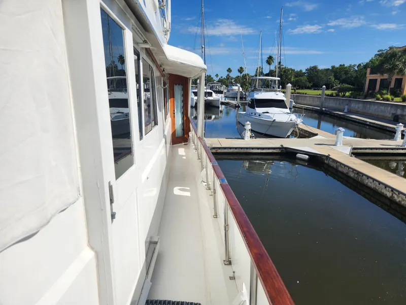 Slide: The Image of 1979 Hatteras 58 Long Range Cruiser docked at marina under clear blue sky. - 20