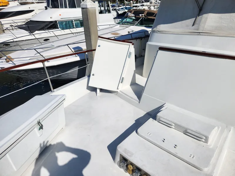 Slide: The Image of 1979 Hatteras 58 Long Range Cruiser deck with storage compartments, docked at marina. - 27