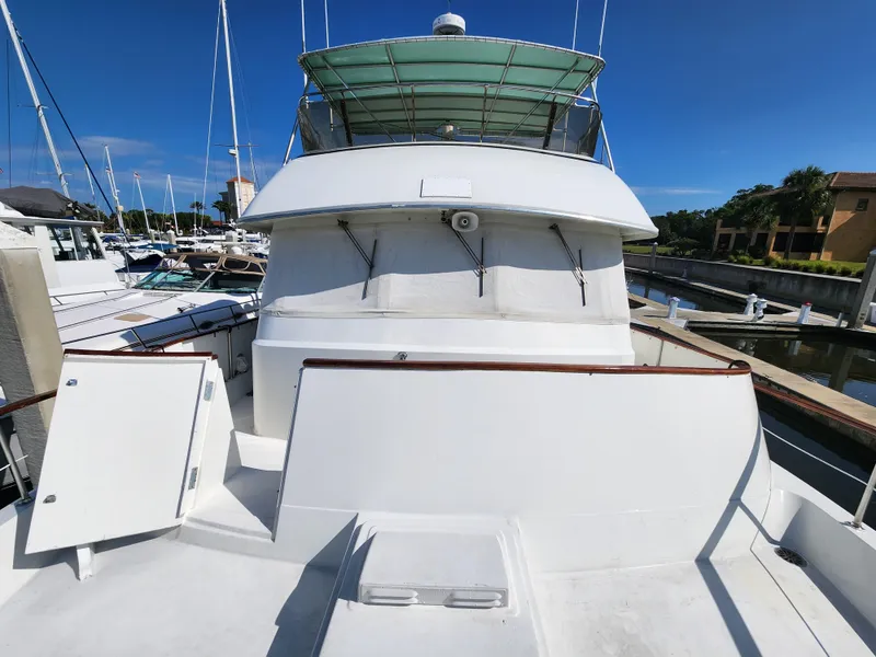 Slide: The Image of 1979 Hatteras 58 Long Range Cruiser docked at marina under clear blue sky. - 29
