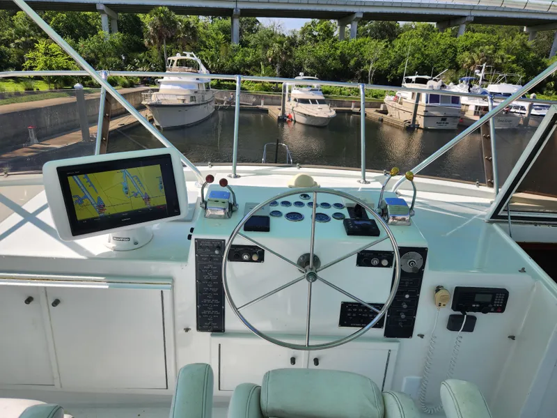 Slide: The Image of 1979 Hatteras 58 Long Range Cruiser helm with navigation equipment and marina view. - 33