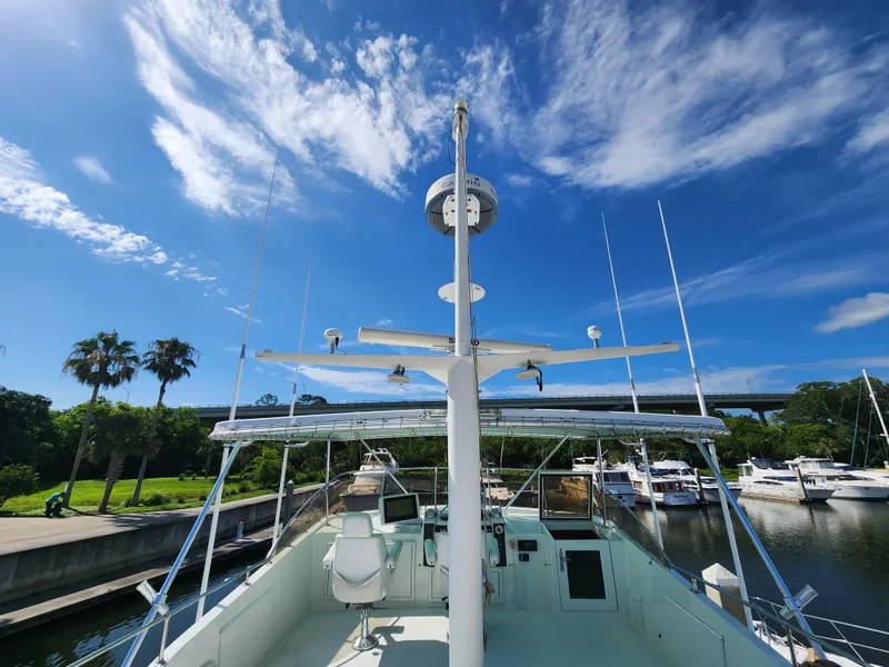 Slide: The Image of 1979 Hatteras 58 Long Range Cruiser docked under a vibrant blue sky. - 36