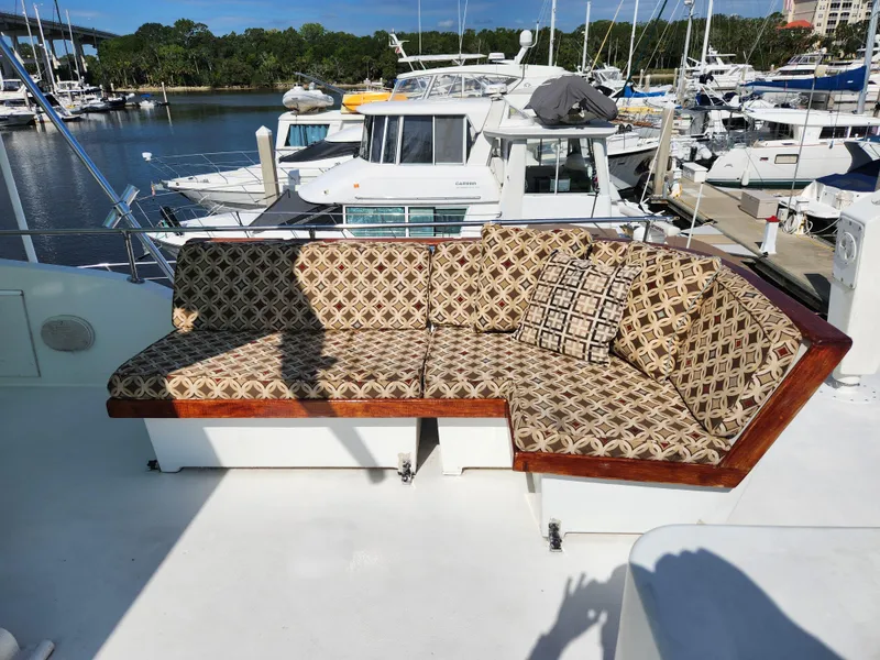 Slide: The Image of 1979 Hatteras 58 Long Range Cruiser with patterned outdoor seating on deck, docked at marina. - 39