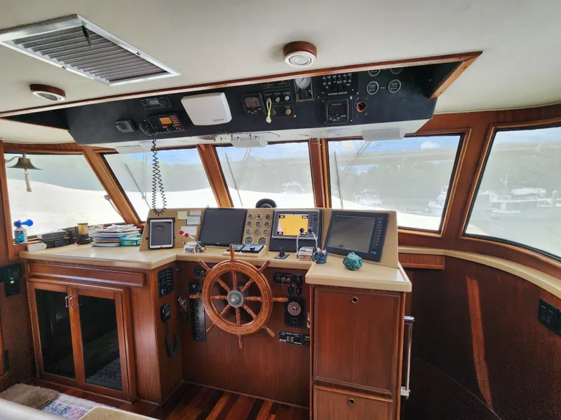 Slide: The Image of 1979 Hatteras 58 Long Range Cruiser helm with wooden wheel and navigation equipment. - 46