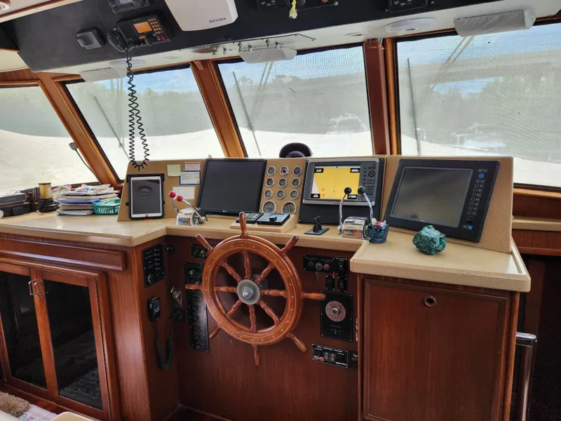 Slide: The Image of 1979 Hatteras 58 Long Range Cruiser helm with navigation equipment and wooden steering wheel. - 47