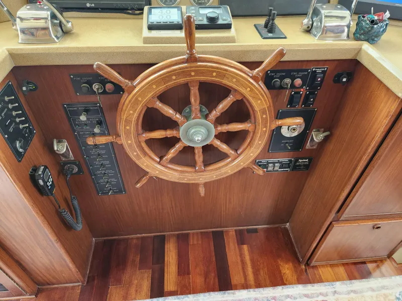 Slide: The Image of 1979 Hatteras 58 Long Range Cruiser helm with wooden wheel and control panels. - 48