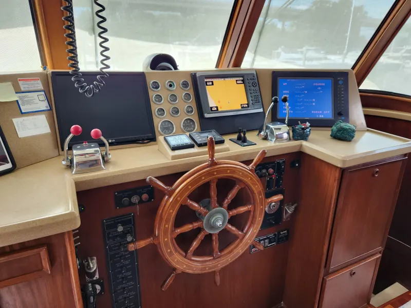 Slide: The Image of 1979 Hatteras 58 Long Range Cruiser helm with navigation equipment and wooden steering wheel. - 49