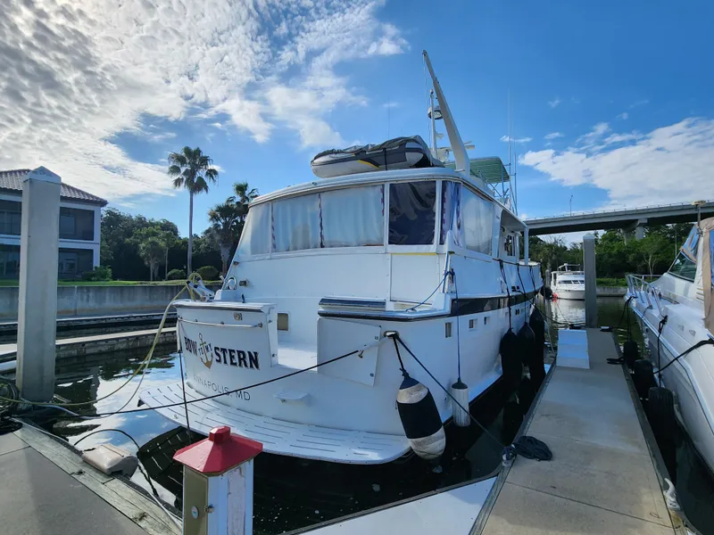 Slide: The Image of 1979 Hatteras 58 Long Range Cruiser docked at marina under blue sky. - 5