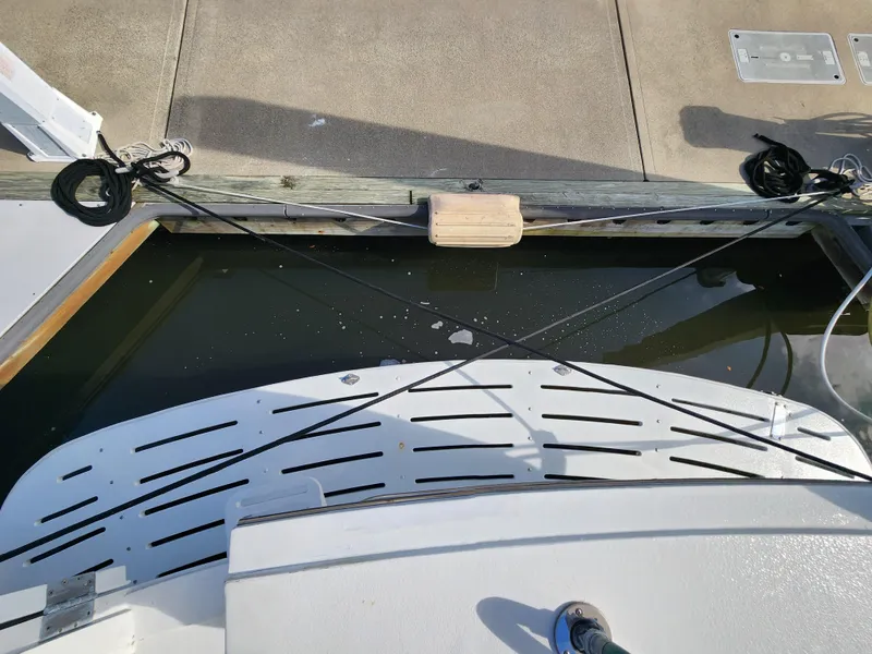 Slide: The Image of 1979 Hatteras 58 Long Range Cruiser docked, showing stern and mooring lines. - 9