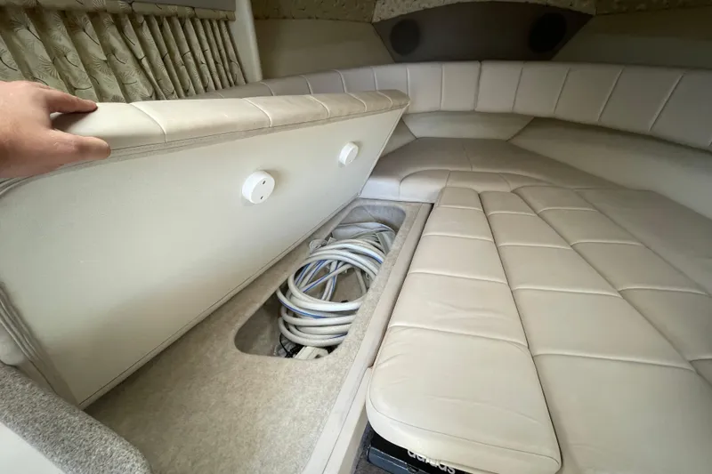 Slide: The Image of Interior of a 2000 Formula 330 SS boat showing storage compartment under cushioned seating. - 10