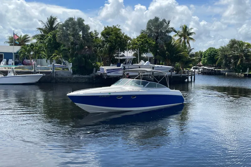 Slide: The Image of 2000 Formula 330 SS boat cruising on a calm, scenic waterway with lush greenery. - 31