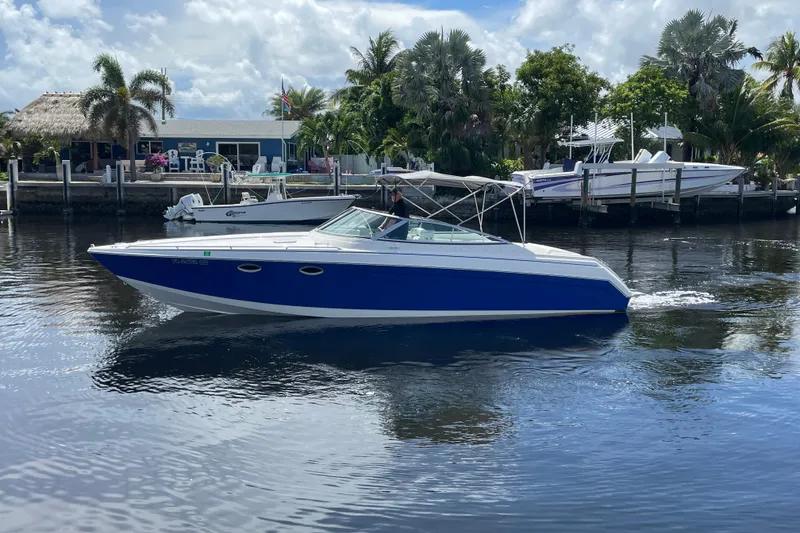 Slide: The Image of 2000 Formula 330 SS boat cruising on a calm waterway with lush greenery. - 32
