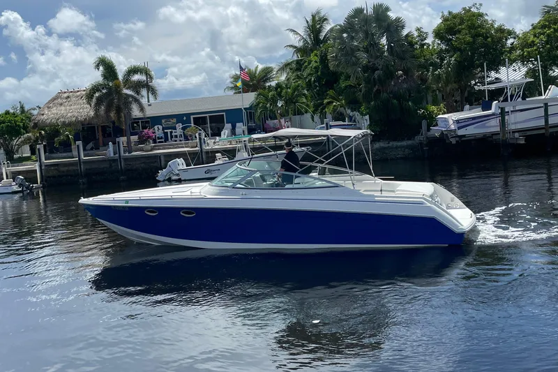 Slide: The Image of 2000 Formula 330 SS boat cruising on a sunny day near a tropical waterfront. - 34