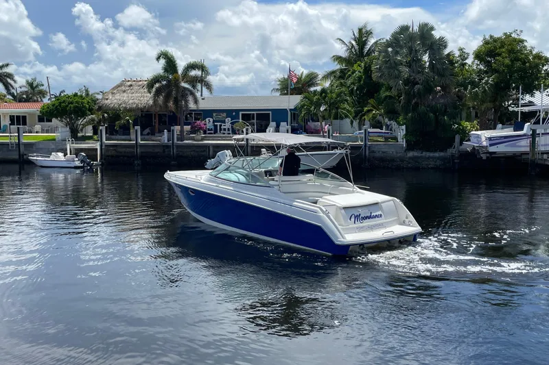 Slide: The Image of 2000 Formula 330 SS boat cruising on a sunny waterfront with palm trees. - 35