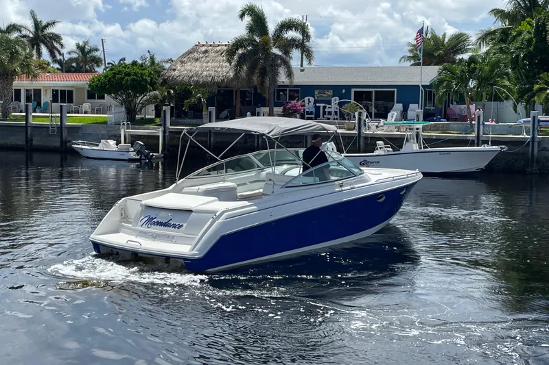 Slide: The Image of 2000 Formula 330 SS boat cruising near waterfront homes, under a sunny sky. - 37
