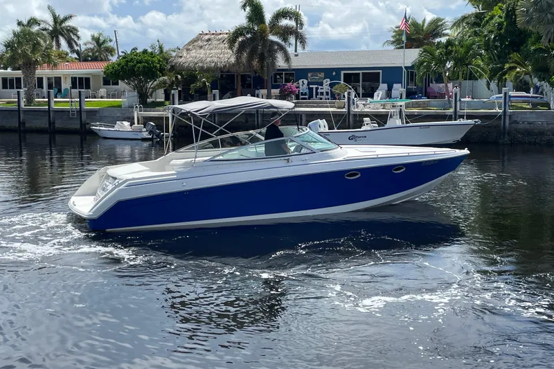 Slide: The Image of 2000 Formula 330 SS boat cruising on a sunny day near waterfront homes. - 38