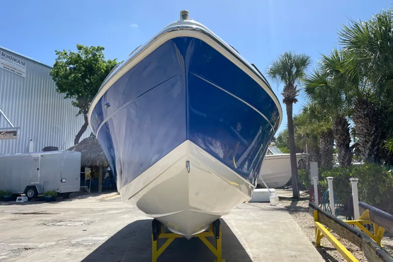 Slide: The Image of 2000 Formula 330 SS boat on display at marina, surrounded by palm trees. - 6