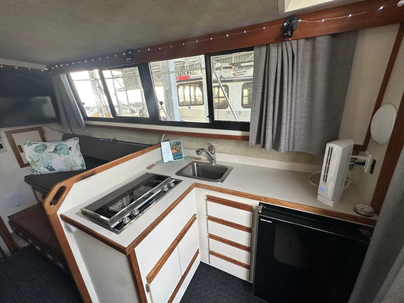 Slide: The Image of 1988 Carver 280 Voyager interior with kitchenette, stove, sink, and mini fridge. - 11